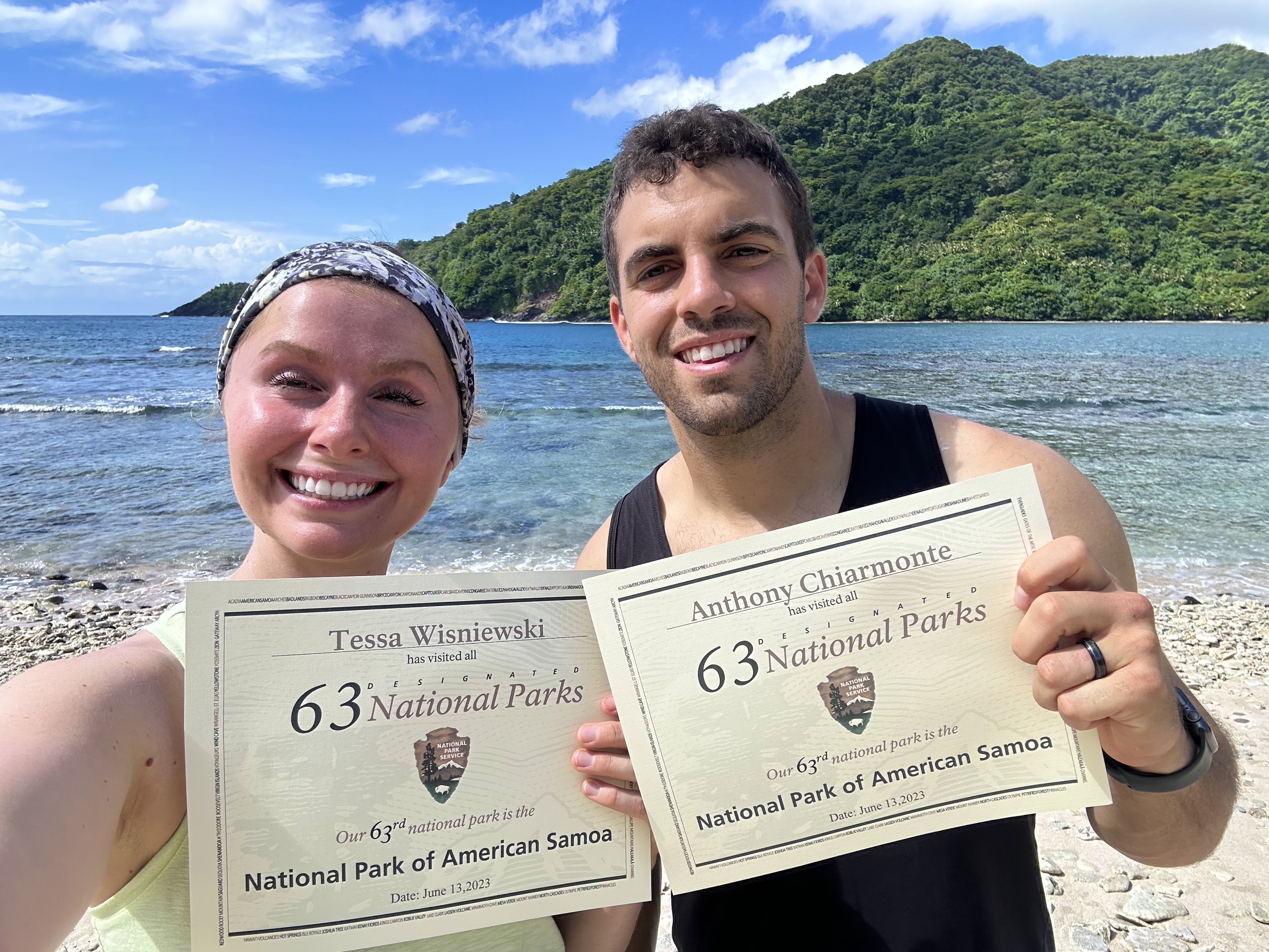 Tessa Wisniewski鈥�17, 鈥�19 and her husband holding up certificates that say 63 National Parks