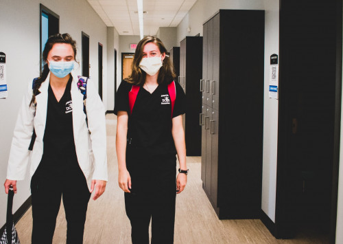 Two female PA students walking down the CILS hallway