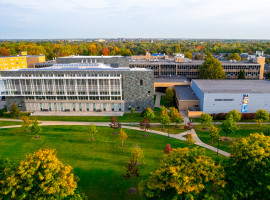 High drone view of front of campus in the fall. RIC and Gymnasium in foreground